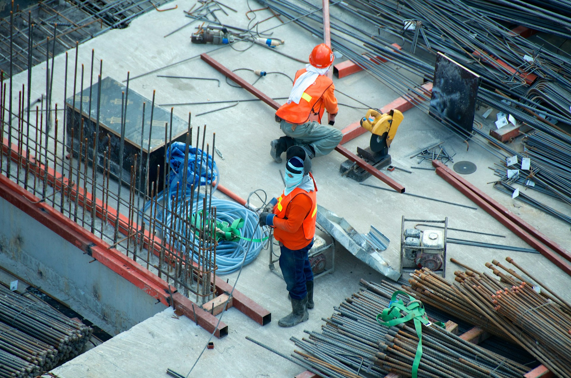 Workers with rebar on concrete foundation site