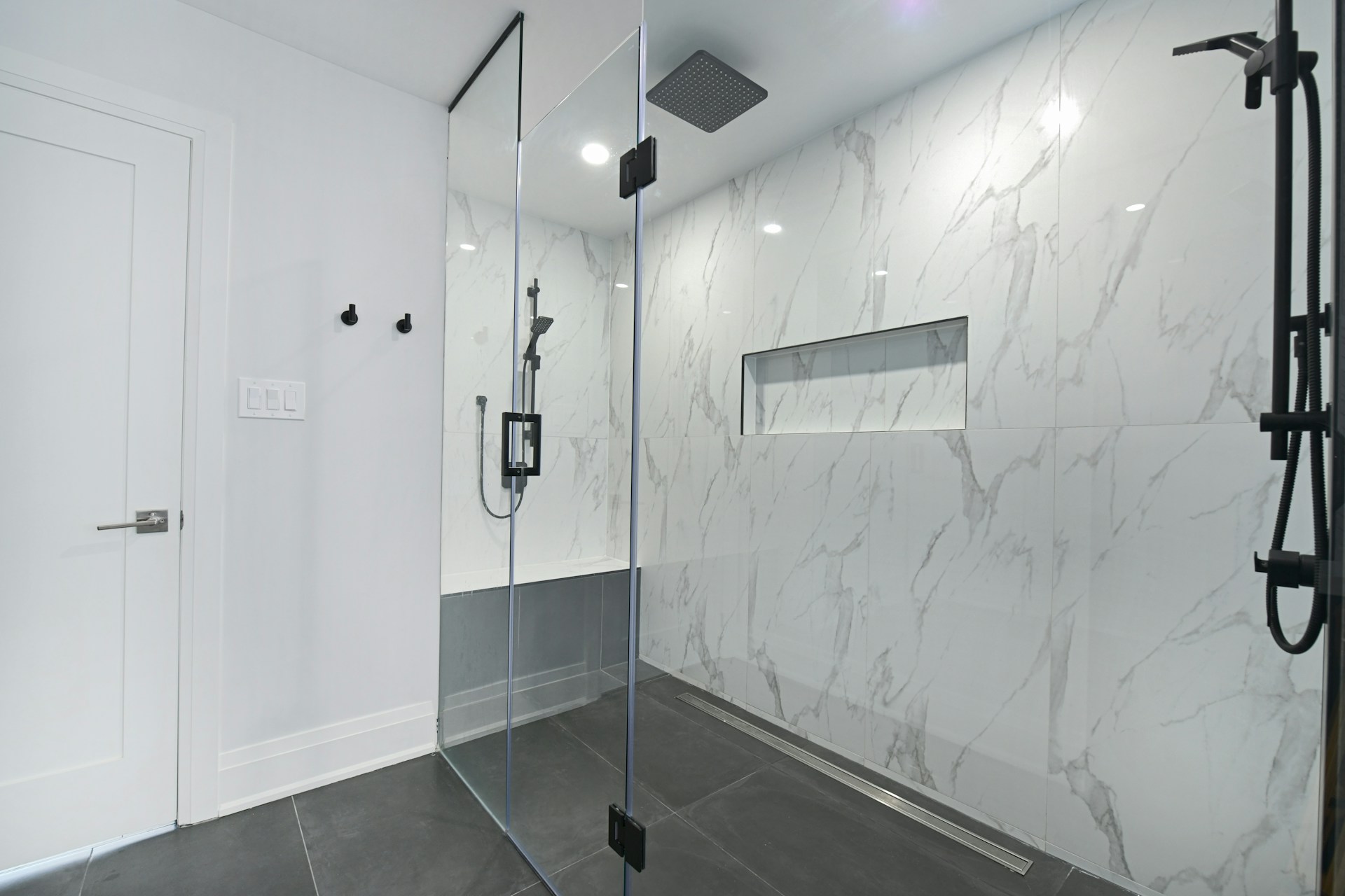 Modern frameless glass shower with marble tiles